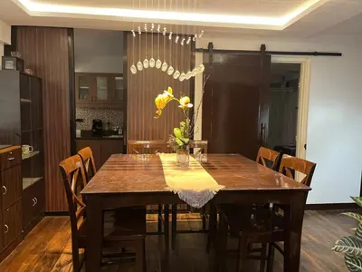 a dining room table with chairs and a vase of flowers at Spacious 3BR with Huge TV near BGC Makati Airport in Manila