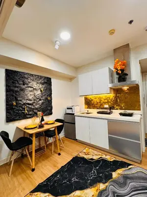 a kitchen with white cabinets and a table and chairs at Azure Urban Resort paranaque in Manila
