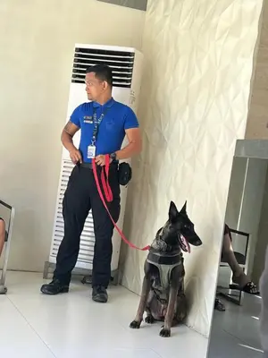 a man with a camera and a dog on a leash at Azure Urban Resort paranaque in Manila