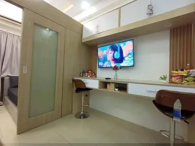 a room with a bar with a tv on a wall at Cozy Couple Room in Manila