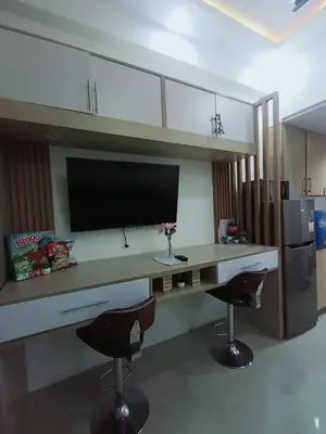 a kitchen with a desk with a tv and two chairs at Cozy Couple Room in Manila