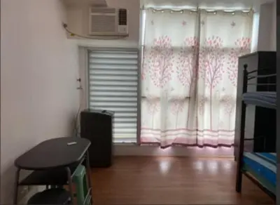 a room with a window with a fan and a window with at Cozy Couple Room in Manila