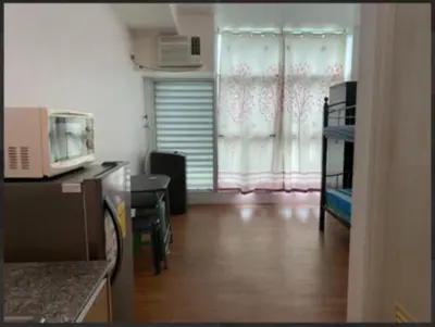 a living room with a kitchen with a microwave at Cozy Couple Room in Manila