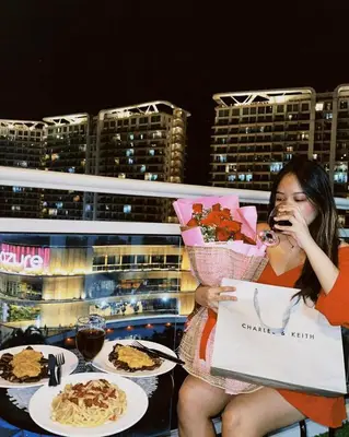 a woman sitting at a table eating food at Lé Boom's Staycation in Manila