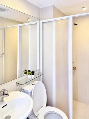 a bathroom with a white toilet and a sink at Lé Boom's Staycation in Manila
