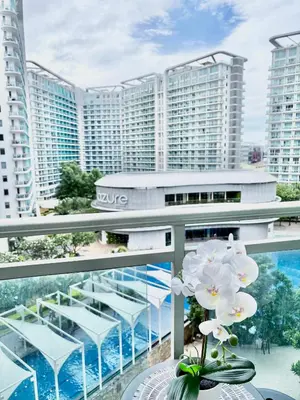 a balcony with a table with a vase of flowers at Lé Boom's Staycation in Manila
