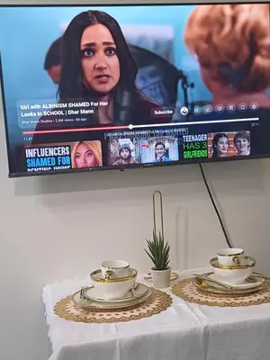 a table with two cups and a tv on top at Cozy Suites in Air residence in Manila