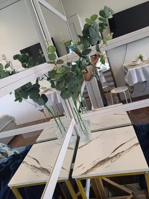 a plant in a vase on a table in front of a mirror at Cozy Suites in Air residence in Manila