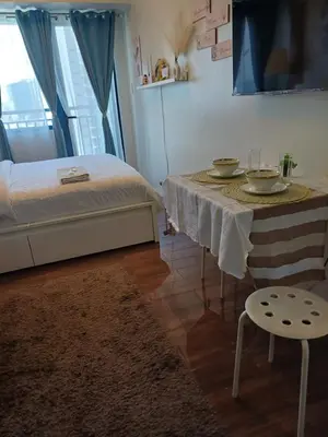 a room with a bed and a table with dishes on it at Cozy Suites in Air residence in Manila