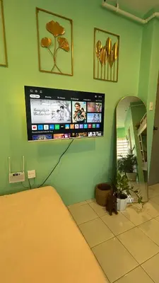 a bedroom with a bed and a tv on the wall at Enchanted Home - Near Enchanted Kingdom in Santa Rosa