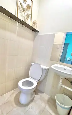 a bathroom with a toilet and a sink at Enchanted Home - Near Enchanted Kingdom in Santa Rosa