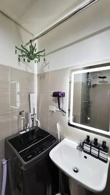a bathroom with a sink and a mirror at Elegant with Best View Fast Wifi Mall of Asia Airport in Manila