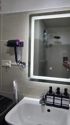 a bathroom sink with a mirror above a sink at Elegant with Best View Fast Wifi Mall of Asia Airport in Manila
