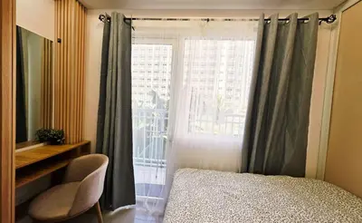 a bedroom with a window with a bed and a chair at Elegant with Best View Fast Wifi Mall of Asia Airport in Manila
