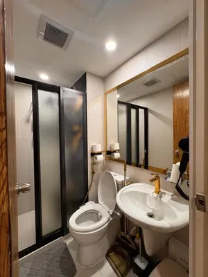 a bathroom with a toilet and a sink at Azure Urban Resort paranaque velvet horiyama in Manila