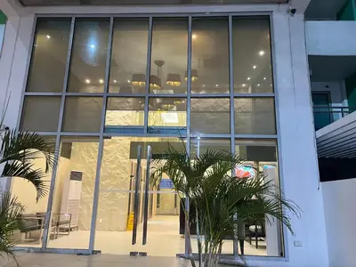 a large glass building with palm trees in front of it at Azure Urban Resort paranaque velvet horiyama in Manila