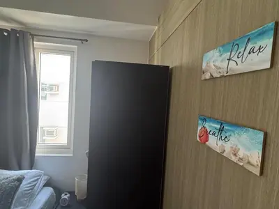 a black refrigerator in a room with a window at 2br Beach KTV Condo in MOA SMX Okada, Near Airport in Manila