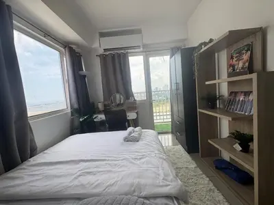 a bedroom with a large bed and a window at 2br Beach KTV Condo in MOA SMX Okada, Near Airport in Manila