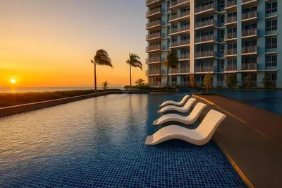 a hotel swimming pool with a white chair in front of a building at Luxurious 3BR near Solaire & Okada w Infinity Pool in Manila
