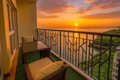 a balcony with a table and a chair and a sunset at Luxurious 3BR near Solaire & Okada w Infinity Pool in Manila