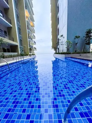 a swimming pool in the middle of two buildings at Luxurious 3BR near Solaire & Okada w Infinity Pool in Manila