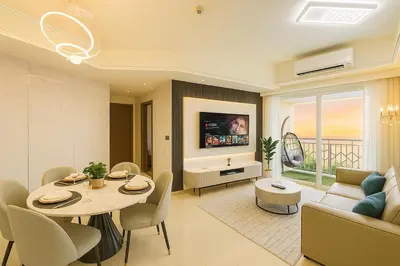 a living room with a table and a couch and a tv at Lovely & Luxury 1BR near Solaire, Okada w Sunset in Manila