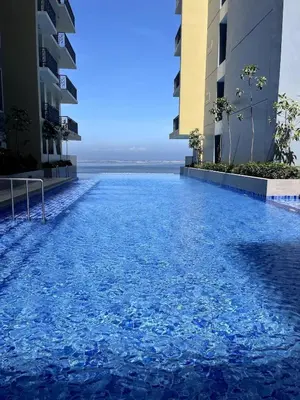 a swimming pool in the middle of two buildings at Spacious & Luxury 1BR near Solaire, Okada, Airport in Manila
