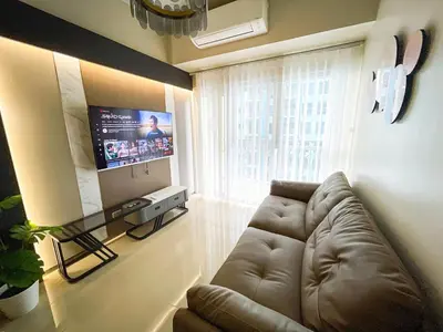 a living room with a couch and a flat screen tv at Spacious 6BR Family Suite near Solaire, Okada in Manila