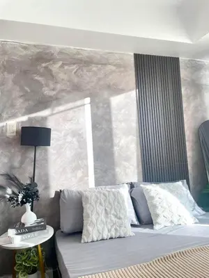 a bed with pillows and a table in a room at SM Bicutan Staycation Bahamas in Manila