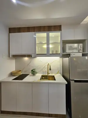 a white kitchen with a sink and a refrigerator at Luxury Condotel Manila by MOA in Manila