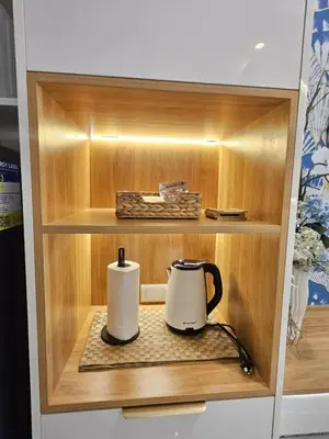 a cupboard with a coffee maker and a tea kettle at Luxury Condotel Manila by MOA in Manila