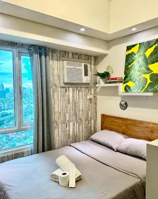 a bedroom with two beds and a window at The Beacon Makati by Christine Suites PH near Greenbelt Mall in Manila