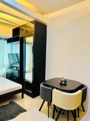 a dining room with a black table and chairs at The Beacon Makati by Christine Suites PH near Greenbelt Mall in Manila