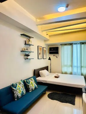 a room with a bed and a couch in it at The Beacon Makati by Christine Suites PH near Greenbelt Mall in Manila