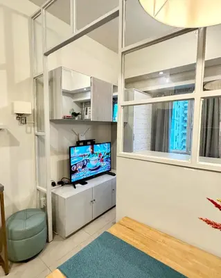 a living room with a tv and a large window at The Beacon Makati by Christine Suites PH near Greenbelt Mall in Manila