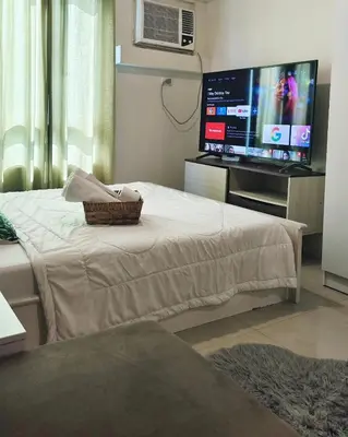 a bedroom with a bed and a flat screen tv at The Beacon Makati by Christine Suites PH near Greenbelt Mall in Manila