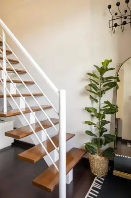 a staircase with white railings and a potted plant at 1 Bedroom Loft in Gramercy Residences Makati in Manila
