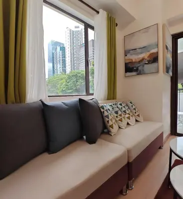 a couch in a living room with a large window at Forbes Town in Manila