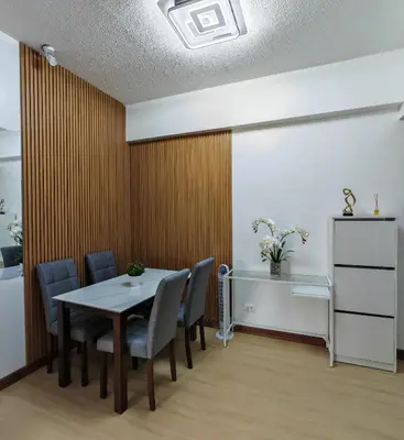 a dining room with a table and chairs at Forbes Town in Manila