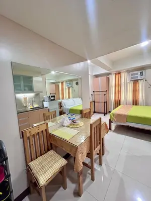 a room with a table and chairs and a bedroom at staycation near manila airport across NAIA terminal 3,13 min drive to terminal 2 and 1, Vexy Condotel located at 101 newport manila in Manila