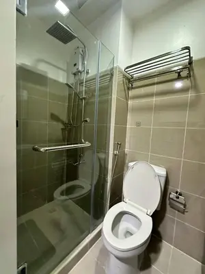 a bathroom with a toilet and a glass shower at Shore Residences Mall of Asia in Manila