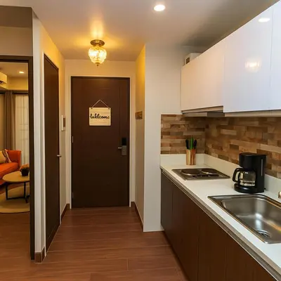a kitchen with a sink and a door to a living room at Skyline escape luxury makati gym swim parking 4649 in Manila