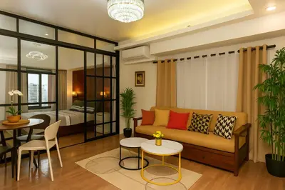a living room with a couch and a bedroom at Skyline escape luxury makati gym swim parking 4649 in Manila