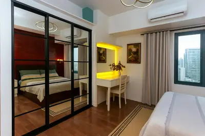 a bedroom with a bed and a desk at Skyline escape luxury makati gym swim parking 4649 in Manila