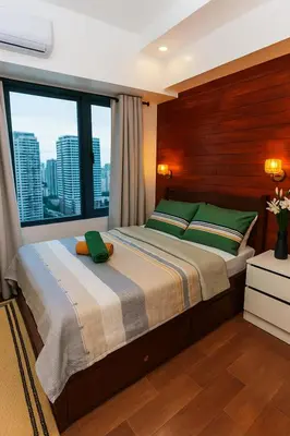 a bedroom with a large bed with a large window at Skyline escape luxury makati gym swim parking 4649 in Manila