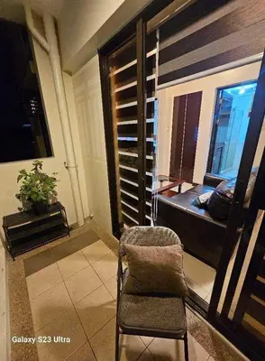 a living room with a chair and a window at 2BR FREE PARKING Calathea Place in Manila