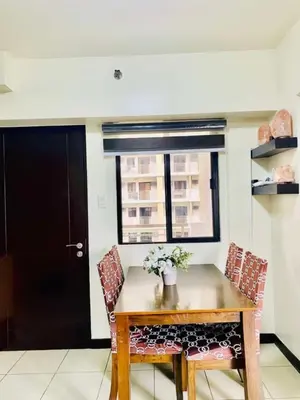 a dining room table with two chairs and a window at 2BR FREE PARKING Calathea Place in Manila