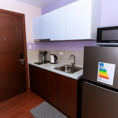 a kitchen with a sink and a refrigerator at Royal rise majestic Makati staycation 5338 in Manila