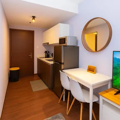 a small kitchen with a table and a refrigerator at Royal rise majestic Makati staycation 5338 in Manila