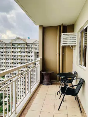 a balcony with two chairs and a table on it at The Atherton by DMCI- 2BR FREE PARKING in Manila